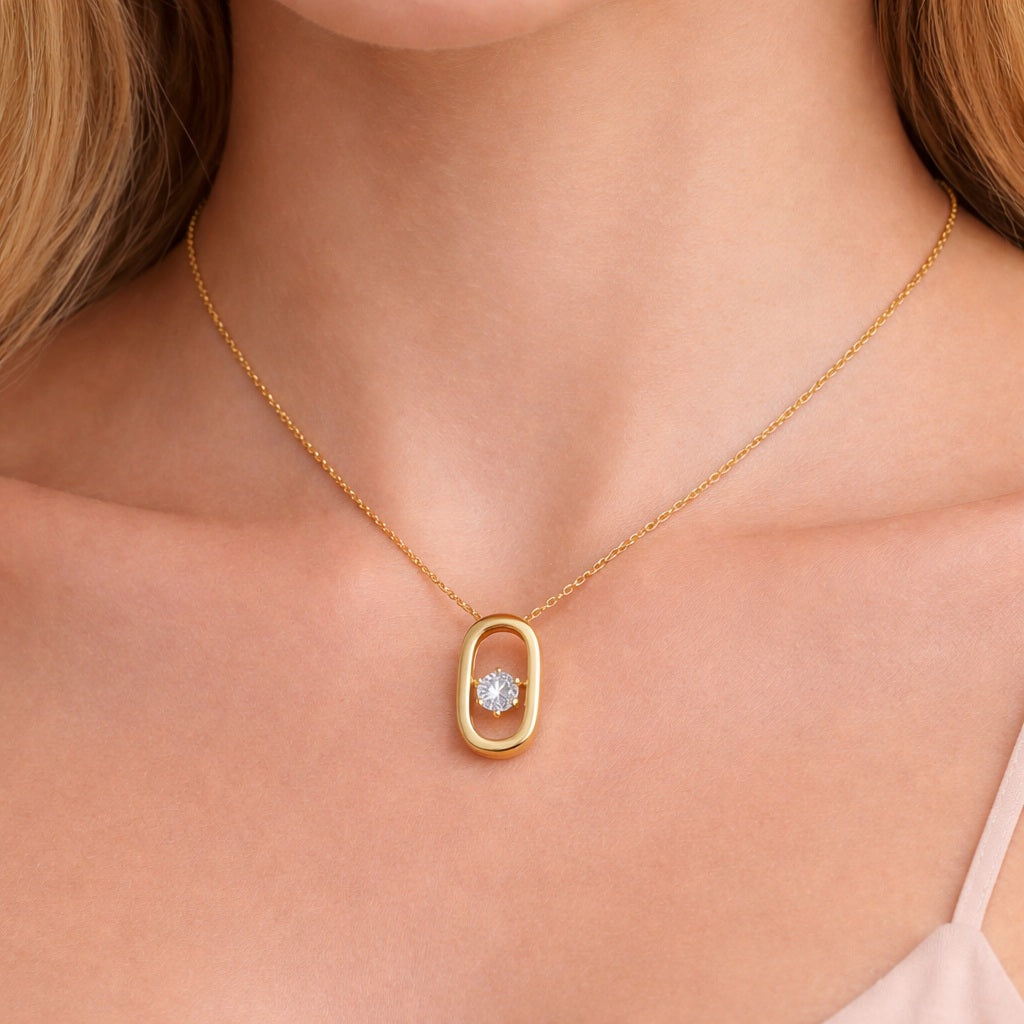 Model wearing a gold plated 925 sterling silver open oval pendant necklace with a single round cubic zirconia