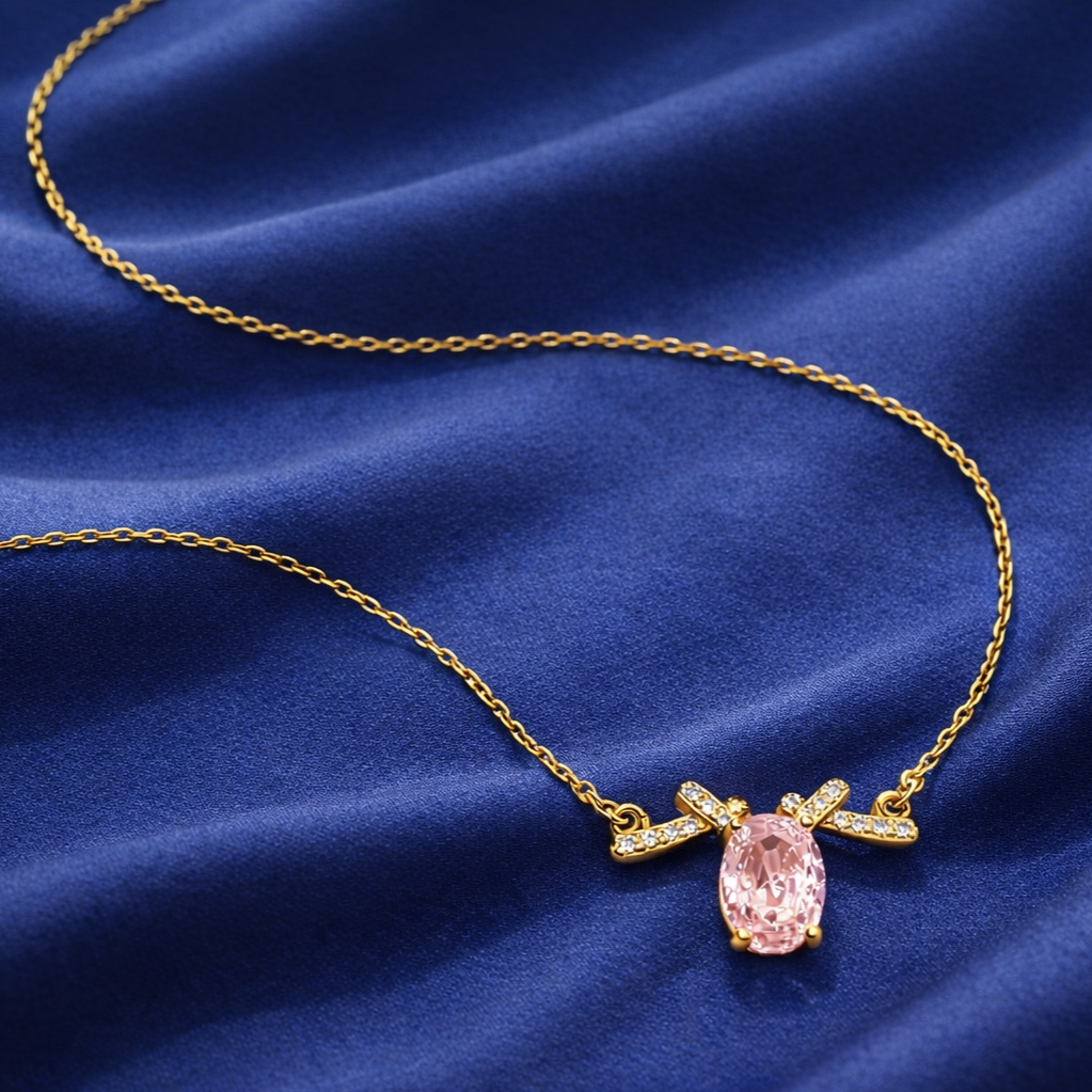 Pink oval stone pendant necklace in 925 sterling silver with gold plating on fabric background