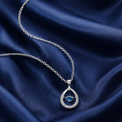 925 sterling silver teardrop pendant necklace with blue dancing stone on fabric background”