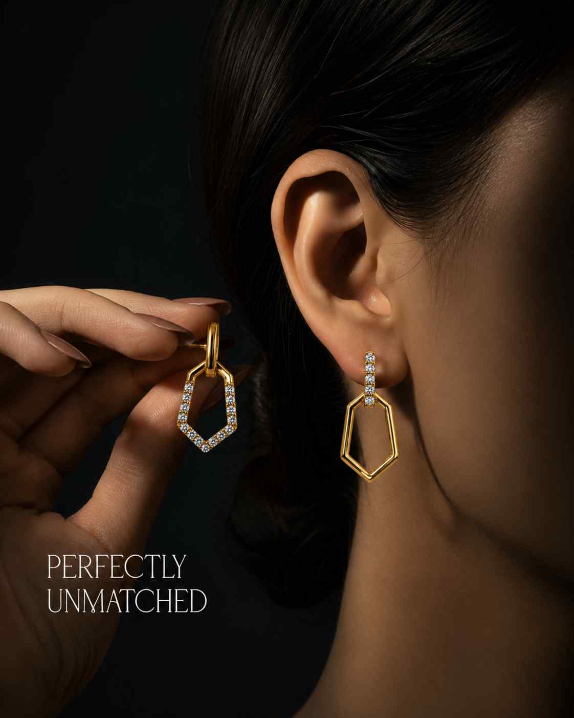 A close-up lifestyle shot of a model wearing a gold geometric hoop earring with clear stones, while another hand holds the matching earring against a dark background. The text 'PERFECTLY UNMATCHED' is visible in the lower-left corner.